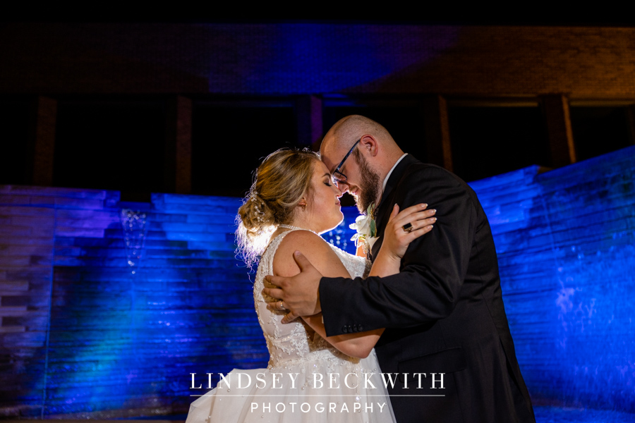 Cleveland Museum of Natural History wedding portrait at night in front of cascade water wall with blue light